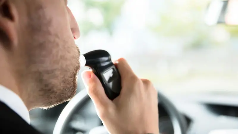 Un uomo fa l'alcol test prima di mettersi alla guida