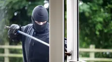 Effrazione di una finestra: un ladro d'appartamento entra in una casa