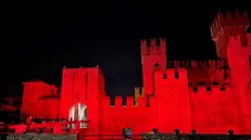 Il castello di Sirmione illuminato di rosso