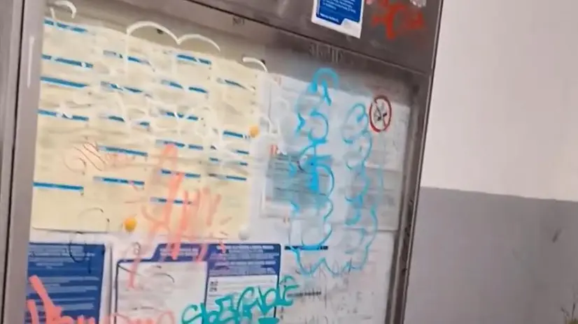Scritte sui muri e sul tabellone alla stazione di Manerbio