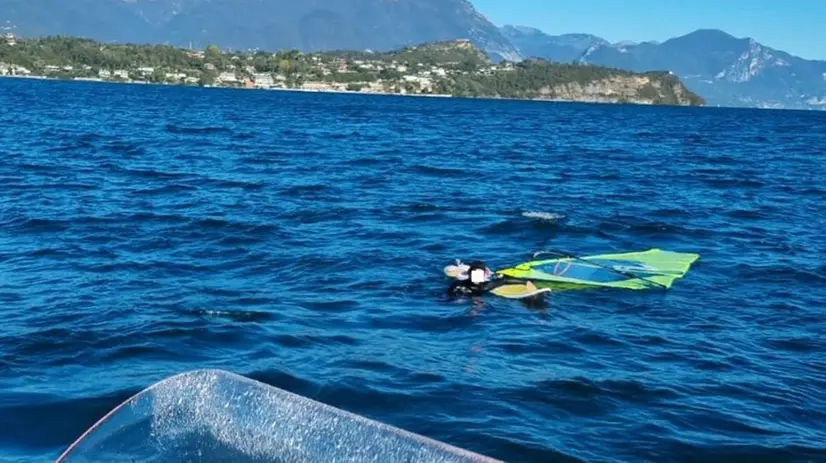 Il 27enne aggrappato alla tavola da windsurf