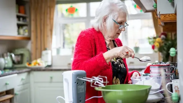 Una donna in cucina alle prese con la preparazione di una torta