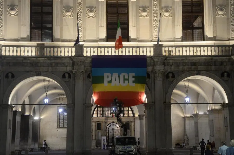 La bandiera della pace sulla facciata di Palazzo Loggia