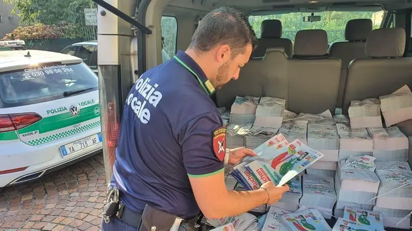 In una foto d'archivio, un agente di Polizia con volantini sequestrati