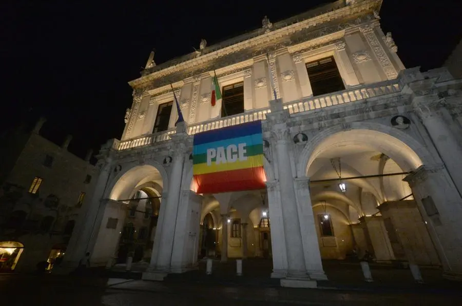 La bandiera della pace sulla facciata di Palazzo Loggia