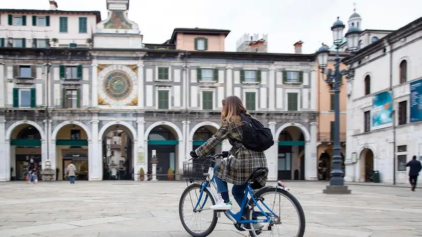 Una ragazza su Bicimia in piazza Loggia