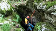 Uno speleologo pronto a calarsi in una grotta - © www.giornaledibrescia.it
