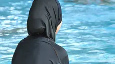 Una donna indossa il burkini in piscina