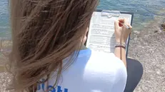 Un'attivista di Legambiente impegnata nelle rilevazioni della Goletta dei Laghi sul Garda