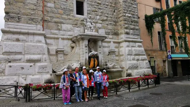 I volontari del gazebo della Pallata in posa sotto la torre - © www.giornaledibrescia.it