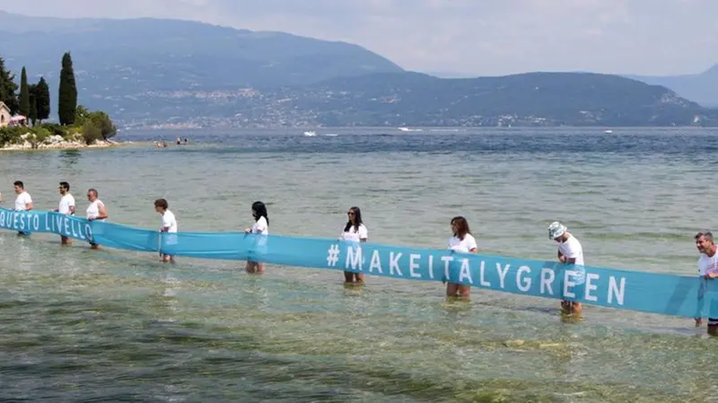 La catena umana per la campagna di E.On nel lago di Garda - Foto © www.giornaledibrescia.it