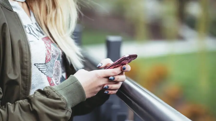 Una ragazzina con un cellulare - Foto unsplash.com