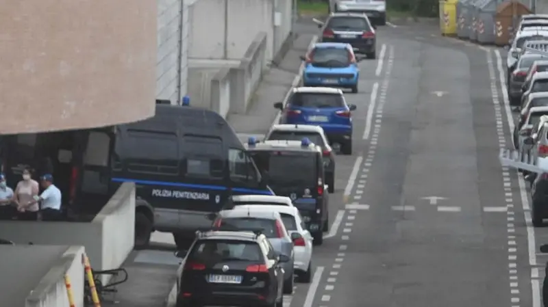 Agenti della Polizia penitenziaria accompagnano un detenuto a piedi verso le aule