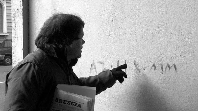 Spinoni, da cronista, sul luogo di un agguato nel 2000: sotto braccio la copia immancabile del GdB - © www.giornaledibrescia.it