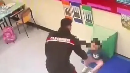 Il carabiniere prende in braccio la bambina