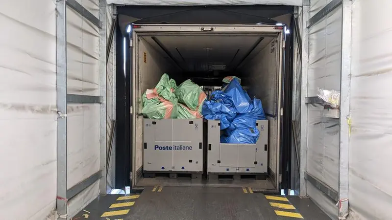 Pacchi in viaggio: il materiale raccolto in uno dei camion delle Poste - © www.giornaledibrescia.it