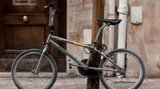 Una bici legata ad un palo - Foto unsplash