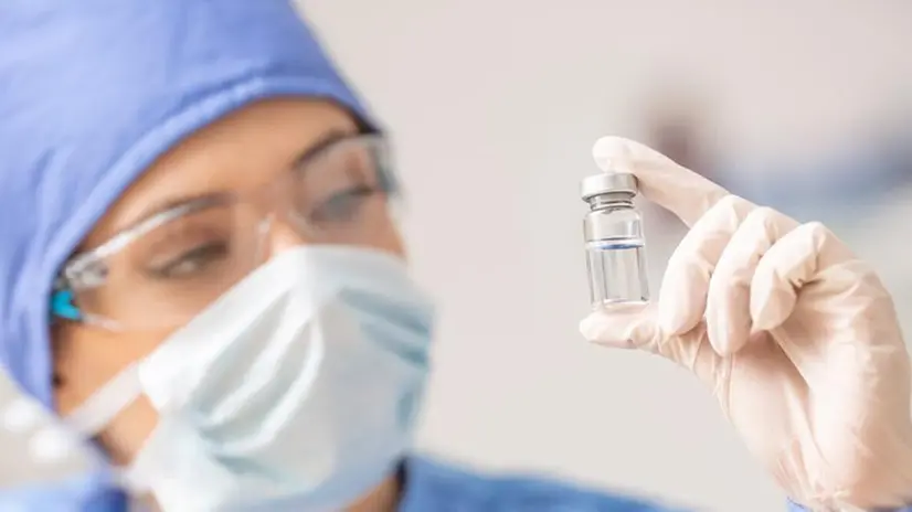 Un'operatrice sanitaria con una fiala di vaccino antinfluenzale - Foto Ansa  © www.giornaledibrescia.it