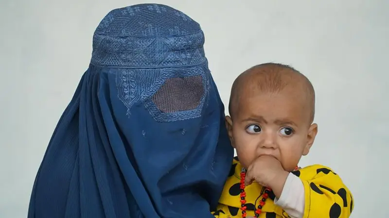 Una donna afghana con il suo bambino