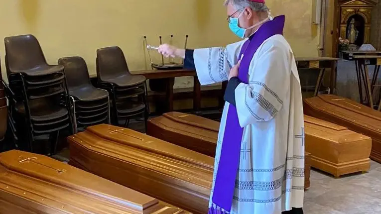 In pieno lockdown il vescovo Pierantonio Tremolada benedice le bare in attesa di sepoltura - © www.giornaledibrescia.it