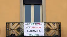 Un cartellone di invito al voto su un balcone in città - Foto Gabriele Strada/Neg © www.giornaledibrescia.it