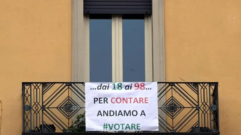 Un cartellone di invito al voto su un balcone in città - Foto Gabriele Strada/Neg © www.giornaledibrescia.it