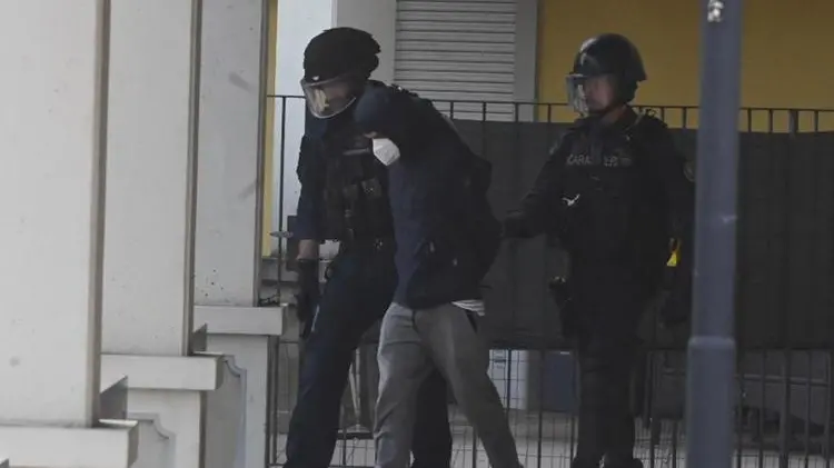 Il 35enne esce dall'appartamento scortato dai militari - Foto Gabriele Strada/Neg © www.giornaledibrescia.it