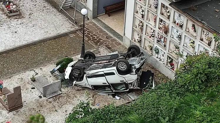 L’utilitaria del 55enne rovesciata sopra i loculi dopo il volo nel dirupo a bordo strada -  © www.giornaledibrescia.it