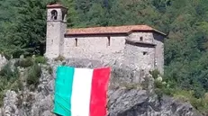 La grande bandiera italiana esposta sotto la rocca di Nozza di Vestone - © www.giornaledibrescia.it