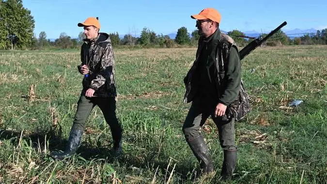 Due cacciatori mentre camminano nei campi nella loro prima uscita stagionale