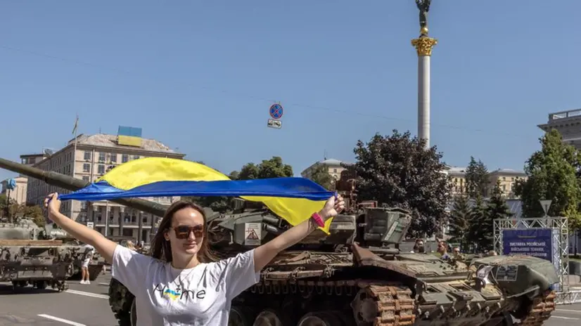 Una ragazza sventola una bandiera ucraina davanti a un carro armato a Kiev - Foto Roman Pipely Epa © www.giornaledibrescia.it