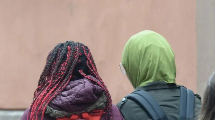 Due ragazze di nazionalità diversa di spalle (foto simbolica) - Foto © www.giornaledibrescia.it