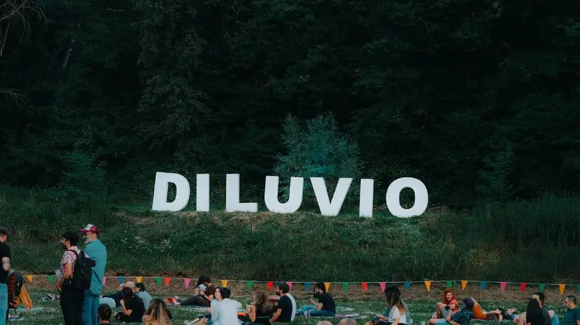 Il pubblico seduto sull'erba in attesa di un evento al Diluvio Festival