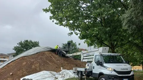 Gli operai al lavoro al parco Parenzo per riposizionare il telo trascinato via dal vento - © www.giornaledibrescia.it