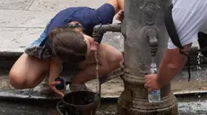 Una ragazza beve a una fontanella - Foto Ansa  © www.giornaledibrescia.it