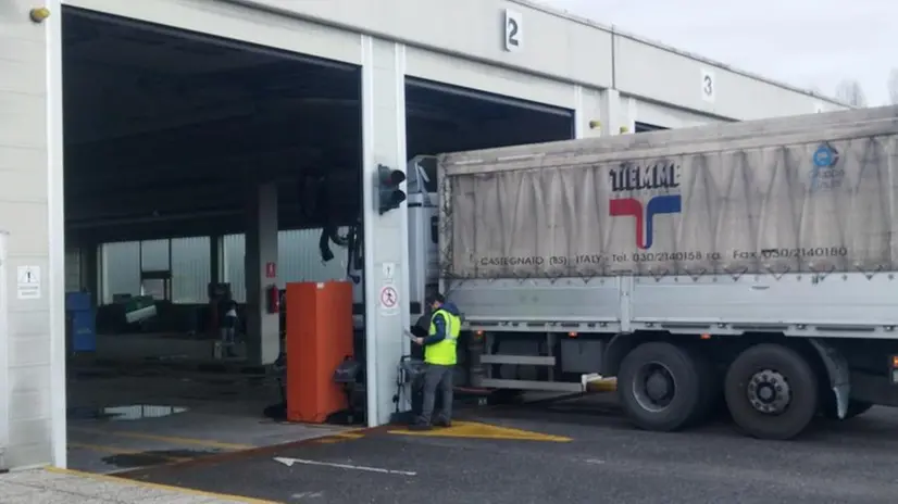 Un tecnico addetto al controllo dei camion in via Grandi - © www.giornaledibrescia.it