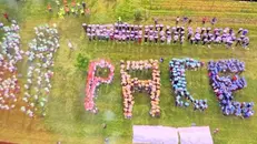 La parola «pace» composta dai bambini che hanno alzato verso il cielo tanti piccoli cartelli colorati - Foto © www.giornaledibrescia.it
