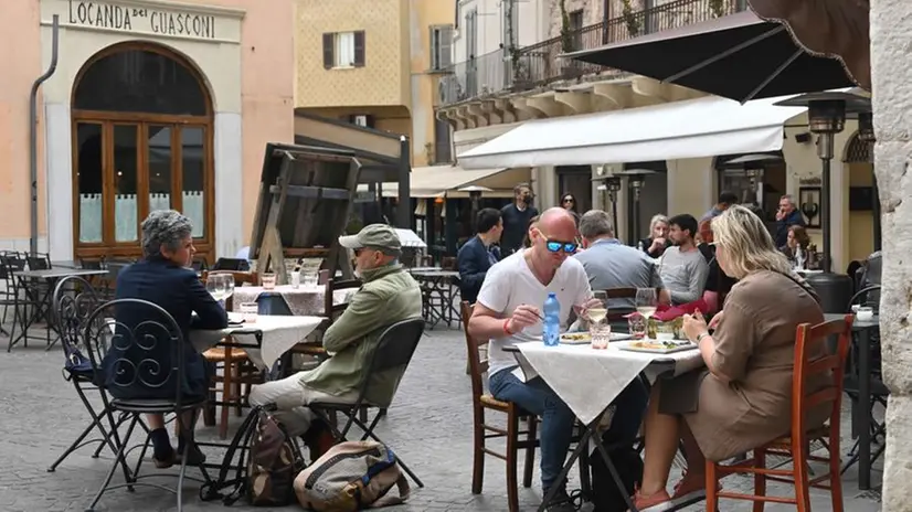 Avventori mangiano all'aperto in alcuni ristoranti del centro