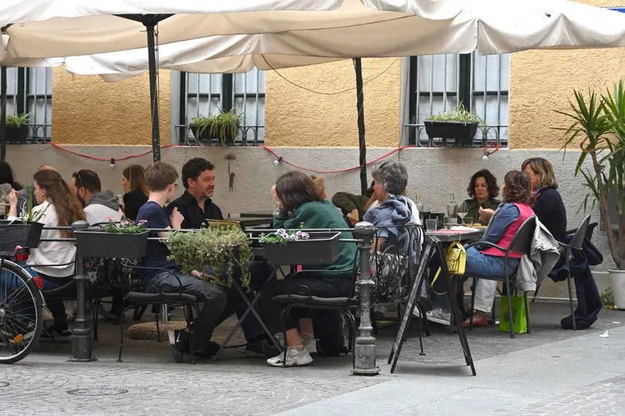Avventori mangiano all'aperto in alcuni ristoranti del centro