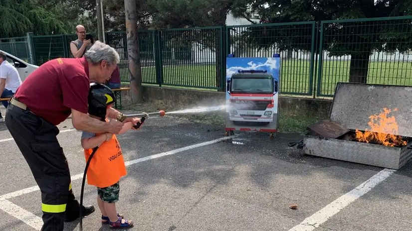 Un bambino spegne un incendio insieme a un Vigile del fuoco - © www.giornaledibrescia.it