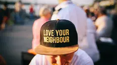 Sul cappellino, la scritta "Ama il tuo vicino"