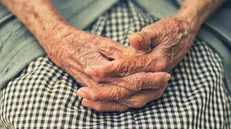 Le mani giunte di un'anziana