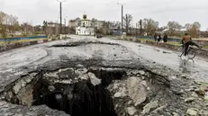 Un cratere causato da un bombardamento su un ponte di Makariv, a nord di Kiev - Foto Oleg Petrasyuk/Epa © www.giornaledibrescia.it