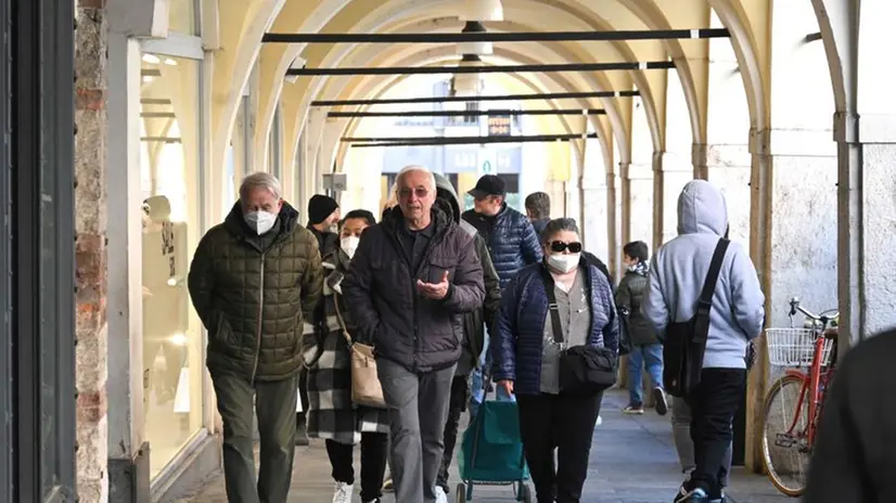 Persone che passeggiano sotto i portici di via X giornate a Brescia - © www.giornaledibrescia.it