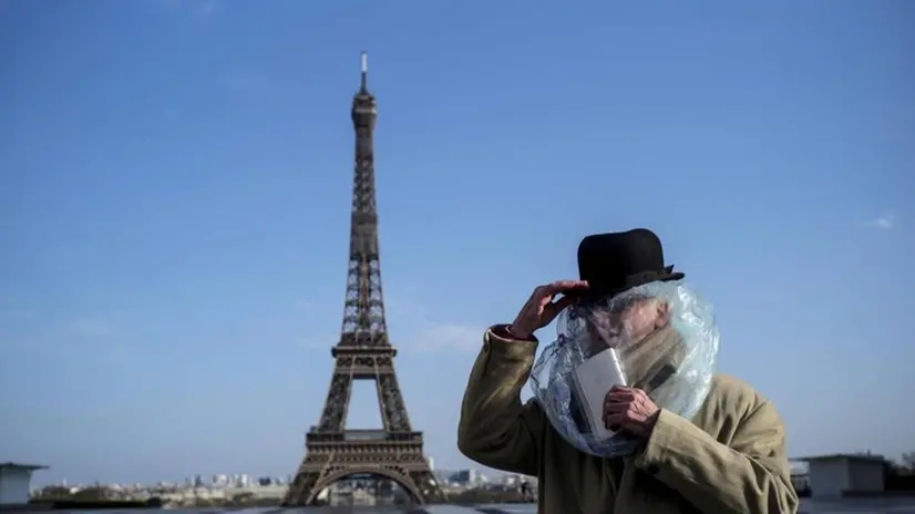 Misure anti-Covid estreme adottate da un passante a due passi dalla Torre Eiffel, uno dei simboli della Vecchia Europa - Foto Epa © www.giornaledibrescia.it
