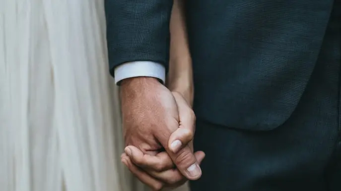 Le mani congiunte di due sposi