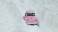 Foto simbolica: un modellino di auto bloccato nella neve