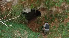 Un ricercatore davanti all’ingresso della grotta chiamata «Buco del Frate» - Foto © www.giornaledibrescia.it