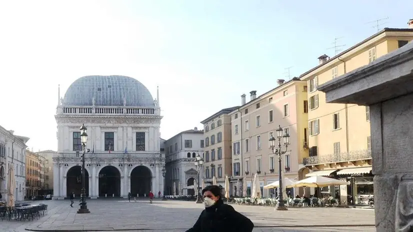 Piazza Loggia deserta, una sola passante con mascherina - Foto Marco Ortogni/Neg © www.giornaledibrescia.it