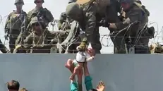 La foto del bambino tratto in salvo dai soldati USA.